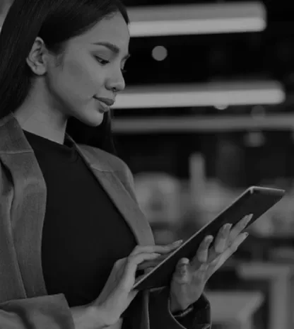 Businesswoman using a digital tablet in a modern office setting.