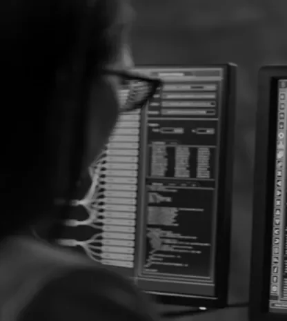 Developer working on multiple monitors displaying code.