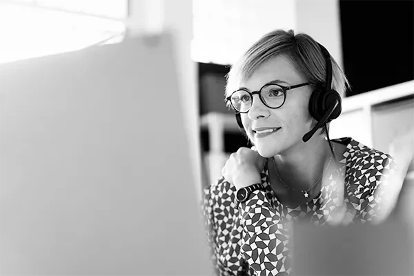 Woman with a headset looking at a computer screen